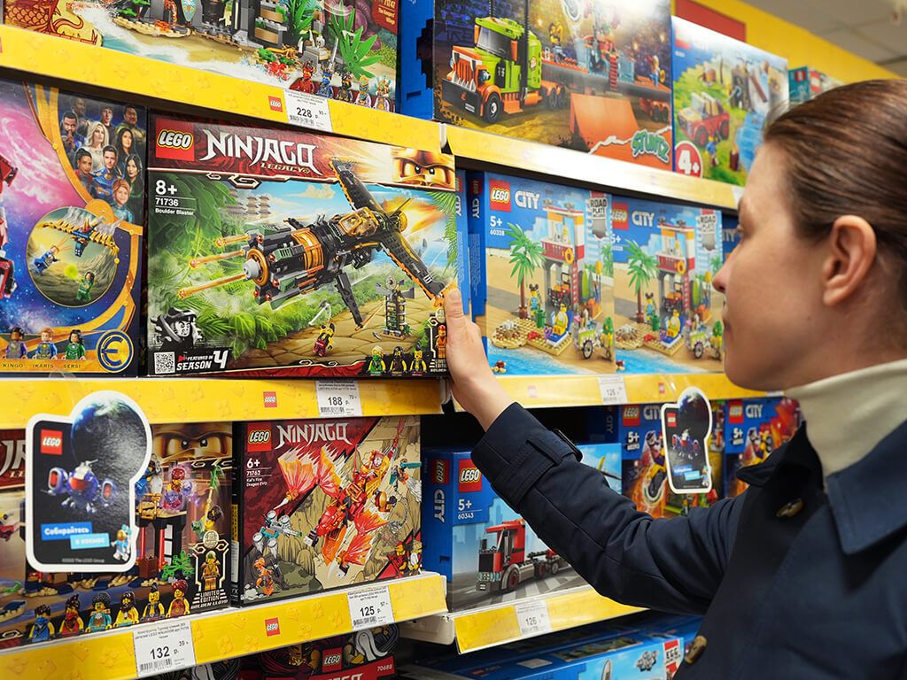 Woman chooses Lego as a gift for a child.