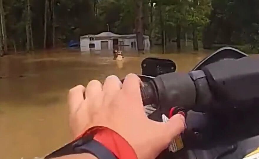 A Houston police officer used a personal watercraft to rescue a man and three dogs amid severe flooding in Texas on Saturday.